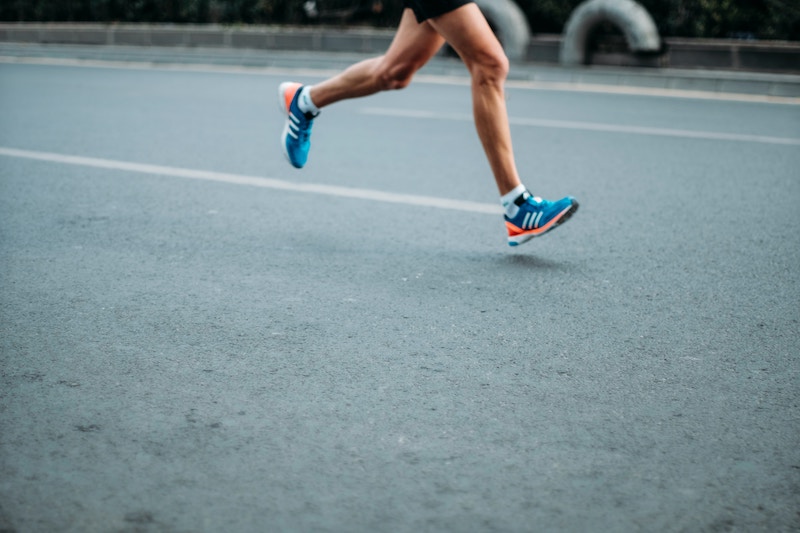 a pair of male legs in trainers running a marathon
